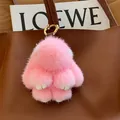 Plush pink mink fur bunny keychain with golden metal ring hanging on a leather bag - Pink Leather Paws