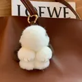 White fluffy mink fur rabbit keychain with gold hardware on a brown leather bag - Coffee Ears Leather Paws