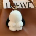 Cute black and white plush rabbit keychain with gold hardware on a leather bag - Black Ears Leather Paws