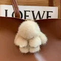 Cute fluffy mink fur bunny keychain in beige hanging on a luxury brown leather tote bag - Khaki Leather Paws