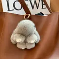Cute gray mink fur rabbit charm with golden metal clasp on a brown leather bag - Natural Gray Leather Paws