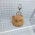 Plush brown cat ball keychain with large yellow eyes and golden metal clip attachment - Khaki