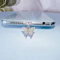 Bouchon anti-poussière papillon argenté avec pierres de zircon sur fond bleu clair - Style Papillon