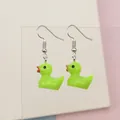 Close-up of cute neon green resin duck earrings with red beaks and silver hooks - Light Green