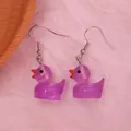 Detailed macro view of cute purple resin duck earrings with silver metal hooks - Luminous Purple