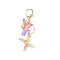 Resin initial X keychain with colorful sequins, purple butterfly, and matching tassel - Style 22