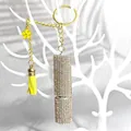 Dettaglio portachiavi a forma di boccetta di profumo con strass, nappa e fiore - Oro champagne