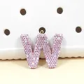 Gros plan d'une breloque lettre W en strass roses avec un anneau de fixation doré - Lettre W en Strass Rose (W)