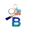 Porte-clés lettre B en résine avec paillettes bleu vert, pompon et papillon doré - Lettre B Paillettes Dégradé Bleu-Vert (QS2157)