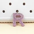 Vue macro du pendentif lettre R incrusté de strass roses avec anneau en métal doré - Lettre R en Strass Rose (R)