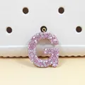 Détail du pendentif lettre G en strass rose avec anneau métallique doré brillant - Lettre G en Strass Rose (G)