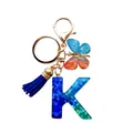 Porte-clés lettre K en résine avec paillettes bleues, pompon et papillon assorti - Lettre K Paillettes Bleu-Vert (QS2157)