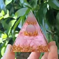 Orgone pyramid with rose quartz, golden foil and lotus charm held in hand outdoors - Pink Cat's Eye Rose Quartz / Small