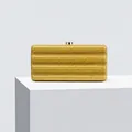 Detail of glitter evening clutch bag with wave texture and gold clasp on white stand - Gold
