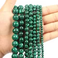 Macro detail of malachite style green beads in various sizes held by hand for comparison - 10mm / Green Malachite