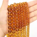 Strands of translucent amber-colored glass beads in various sizes for jewelry making - Amber Glass