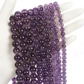 Polished natural purple amethyst round beads held in hand for jewelry making - Amethyst