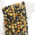 Hand holding natural multi-color tiger eye round beads in various sizes for DIY jewelry - Dreamy Tiger Eye