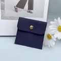 Marineblaue Schmucktasche aus Wildleder mit goldenem Druckknopf und Logodetail - Umschlagbeutel / Marineblau