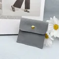 Eleganter grauer Wildleder Schmuckbeutel mit goldener Drucktaste und Logoaufdruck - Umschlagbeutel / Grau