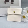 Beige Schmucktasche aus Wildleder mit goldenem Druckknopf und Logoprägung - Cremeweiß; 8x8 cm Beutel (ohne Logo)