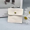Beige suede jewelry envelope pouch with gold button closure and embossed logo - Milky White
