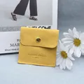 Square yellow microfiber jewelry pouch with gold snap button and debossed logo detail - Earthy Yellow