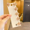 6er-Set Mini-Blumen-Haarclips aus Bernstein-Harz auf weißer Karte in der Hand - Champagner