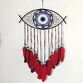 Bohemian Evil Eye dreamcatcher with black woven frame, ribbons, and red feather accents - Red Evil Eye