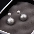 Détail macro de boucles d'oreilles double boule en argent avec texture mate sablée - Argent Dépoli (E845-2)