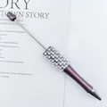 Elegant purple beaded pen with faux pearls and rhinestones on a decorative white background - Purple