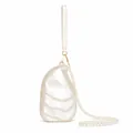 Detailed close-up of shell-shaped acrylic clutch showing pearl texture and pearl strap - Oyster