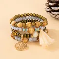 Detail of bohemian multilayer beaded bracelet with tree of life charm and soft tassel - White