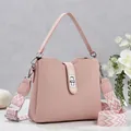 Detail of pink bucket bag with silver twist lock and jacquard patterned wide shoulder strap - Pink