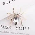 Macro detail of a gold spider brooch with sparkling crystals and a pear-cut centerpiece - Bright Clear Main Stone Spider Brooch