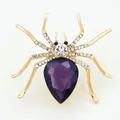 Detailed macro view of a gold spider brooch with purple teardrop gem and rhinestones - Elegant Style Purple Gem Spider Brooch
