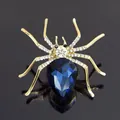 Detailed close-up of golden spider brooch with deep blue teardrop gemstone and crystals - High Quality Teardrop Blue Stone Spider Brooch