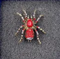 Macro shot of spider brooch with red gemstone and crystals on golden finish - Realistic Vintage Ruby Spider Brooch