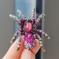Close-up of a spider brooch with pink and purple rhinestones on a gold alloy base - Vintage Personalized Rhinestone Spider Brooch