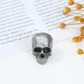 Macro detail of skull-shaped metal ring with distressed finish on vintage book pages - Vintage Distressed 3D Skull Pendant Style