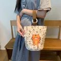 Canvas bucket bag featuring cartoon tiger patterns and a brown top handle - Lucky Tiger