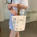 Cream canvas bucket bag with cute illustrations and brown woven straps for daily travel - Best Self