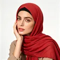 Close-up of deep red Muslim hijab with woven texture and black undercap for women - One Size / Red