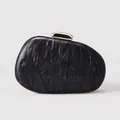 Detailed view of irregular acrylic clutch bag with gray marble texture and gold clasp - Black
