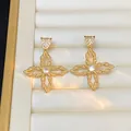 Detailed close-up of golden floral earrings with round zircon inlay in a jewelry box - Gold (925 Sterling Silver Earring Post)