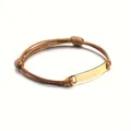 Close-up of a braided leather rope bracelet featuring a polished gold metal plate detail - Brown Rope + Gold Color Plate