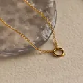 Collana geometrica minimalista color oro con cerchio su sabbia in stile elegante e lussuoso - Collana / Oro