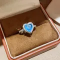 Detailed macro of a heart-shaped blue zircon ring set in a premium brown velvet jewelry box - One Size(Adjustable) / Silver Blue Zirconia