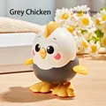 Cute grey clockwork chick toy with yellow accents on a warm wooden background - Wind-up Jumping Chick (Grey)