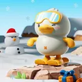 White wind-up jumping duck toy wearing yellow ski goggles and skis on snow - Wind-up Skiing Jumping Duck (White)